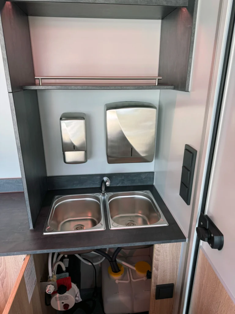 Edelstahl Doppelbecken in einem Hygieneschrank eines Verkaufsanhängers für Fleisch und Wurst