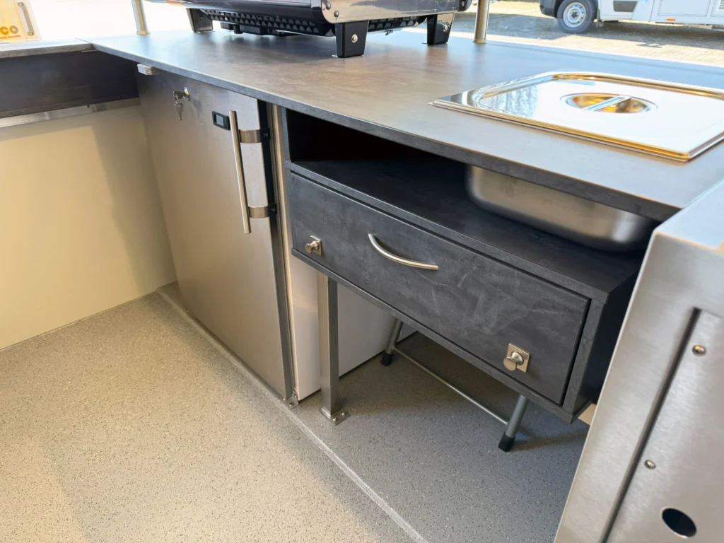 Pommesschublade und Kühlschrank in einem Hähnchengrillwagen