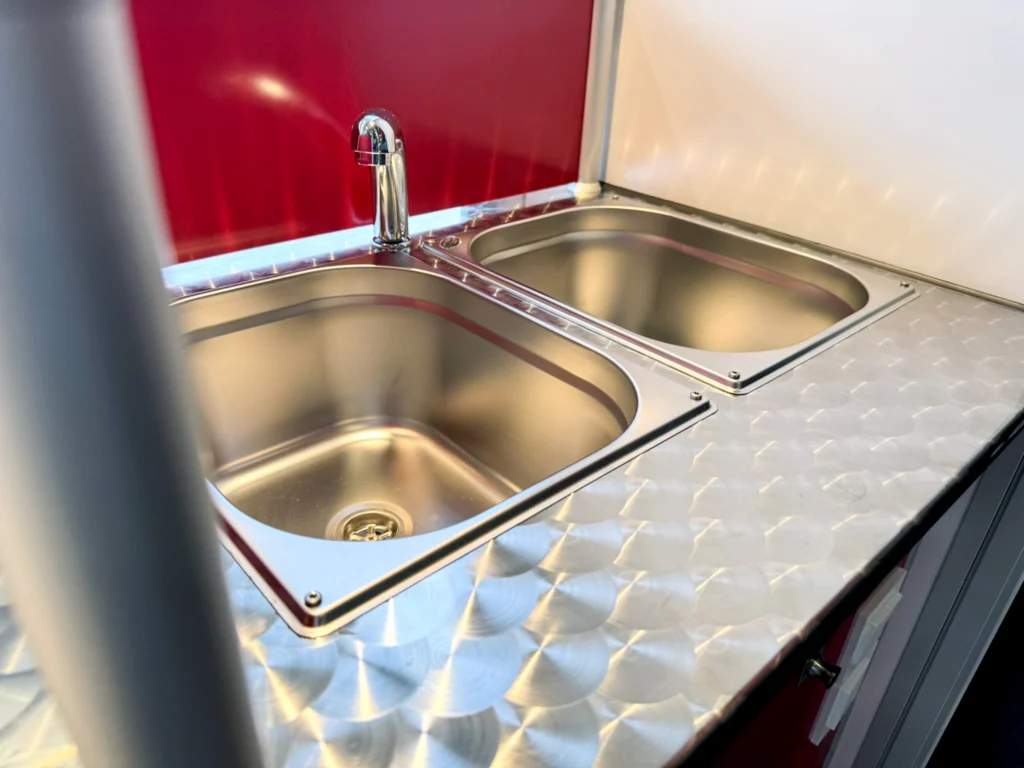 Edelstahlbecken im Hygieneabteil eines mobilen Hähnchengrills