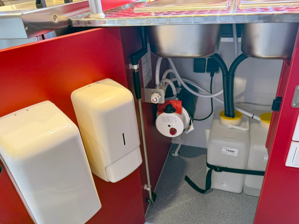Wasserkanister im Hygieneschrank eines mobilen Hähnchengrill