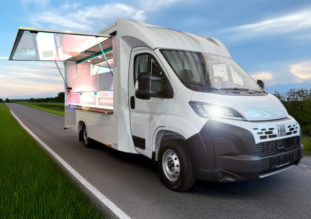 Frontansicht eines Tourenmobils mit Kühltheke auf einer landstraße