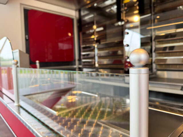 Spritzschutzglas vor den Grillgeräten in einem Hähnchengrillmobil