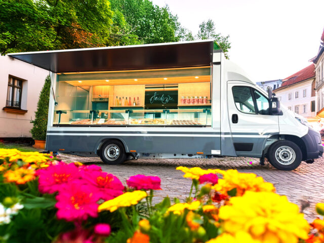 Verkaufsfahrzeug mit Kühltheke in einer Altstadt
